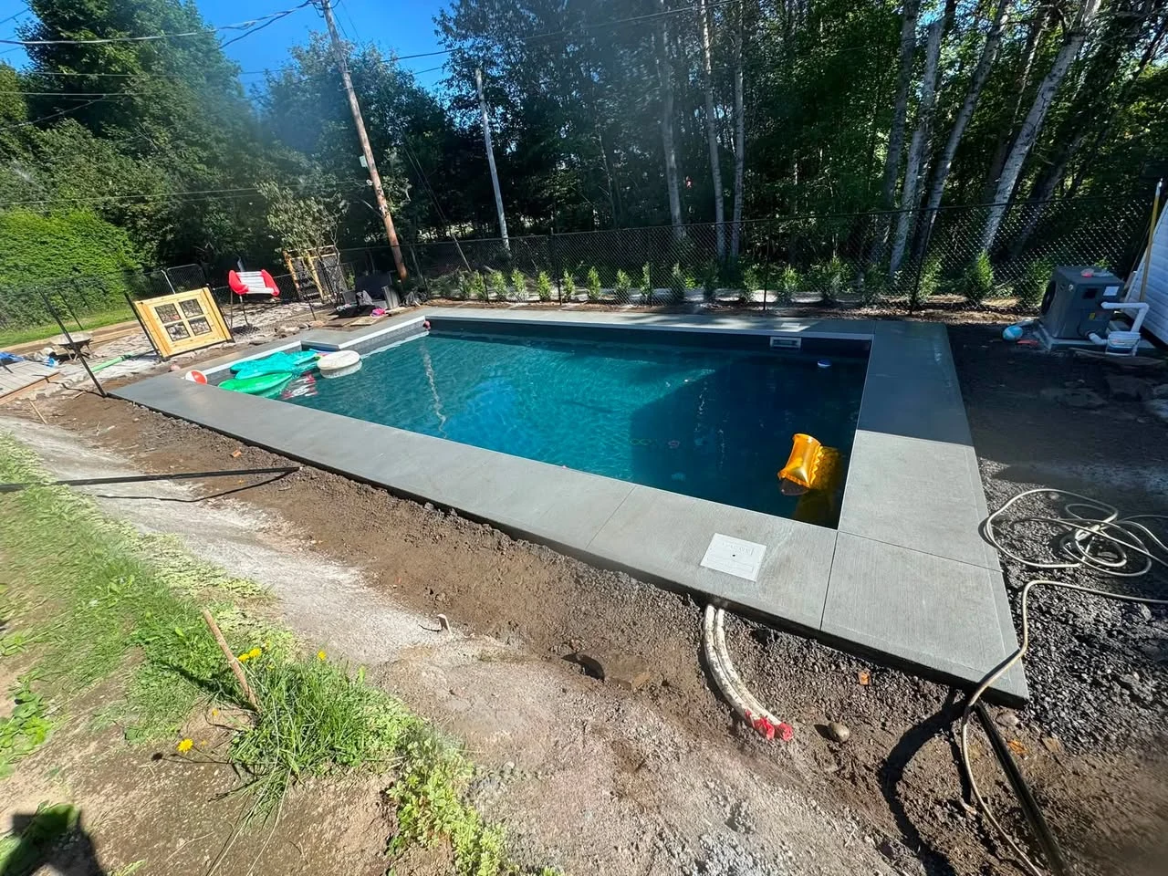 Contour de piscine en béton coulé avec grande terrasse plane, région de Québec