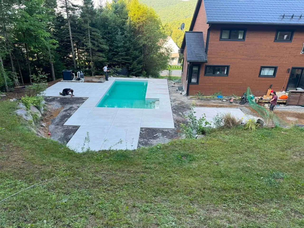 Contour de piscine en béton dans un décor de chalet, région de Québec