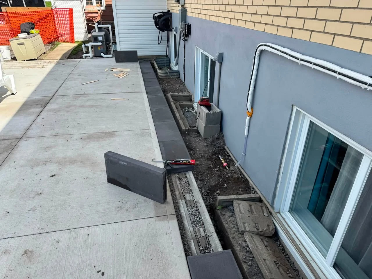 Préparation du drainage et de la base avant de couler une dalle de béton autour d'une piscine
